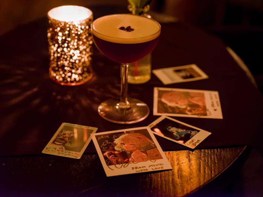 A scattering of chekis from From Minto with Love, surrounding a glass of alcohol.